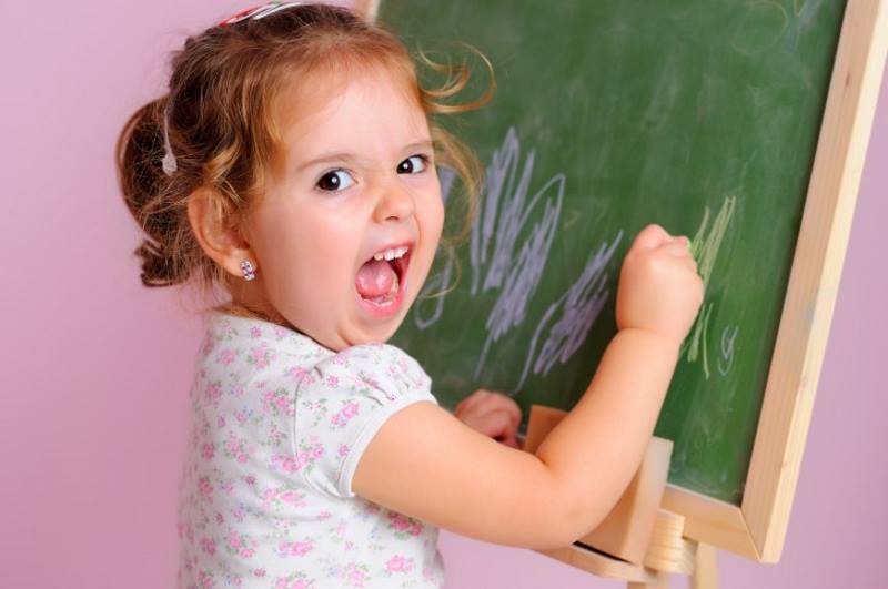 Девочка рисует на доске и кричит