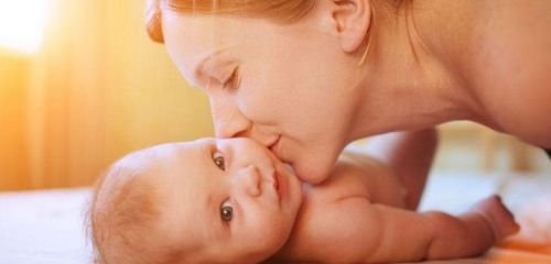Мама целует новорожденного