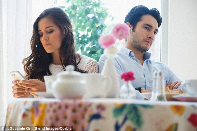 People often struggle to use their smartphones and hold a conversation at the same time. The researchers find that rather than rudely ignoring the people around them, they may simply be deaf to their conversation (a stock image of a woman using a smartphone while while ignoring her partner is pictured)