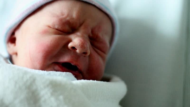 swaddled newborn baby crying