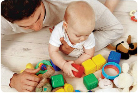 Малыш играет с игрушками совместно с папой