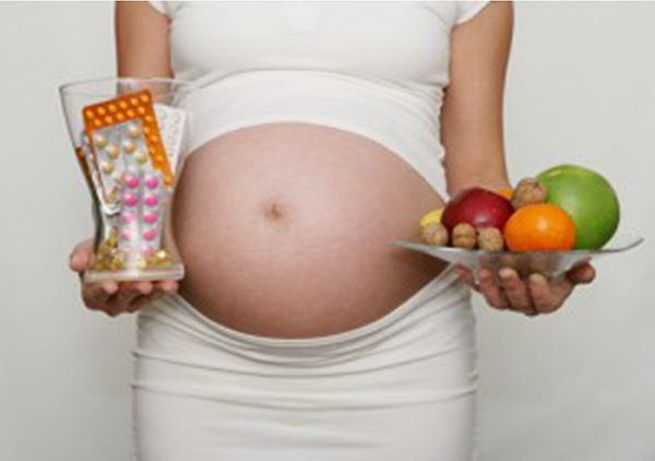 Беременная с таблетками и фруктами
