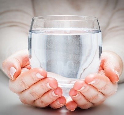 glass of clean mineral water in woman