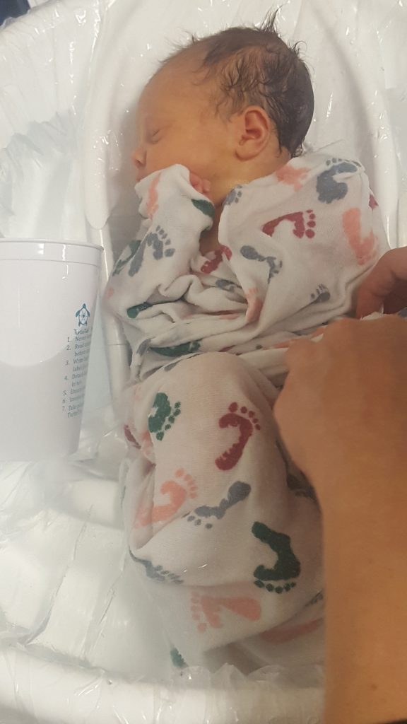 Newborn Alexa Crimando gets her first swaddle immersion bath with help from her parents and a Poudre Valley Hospital nurse. 