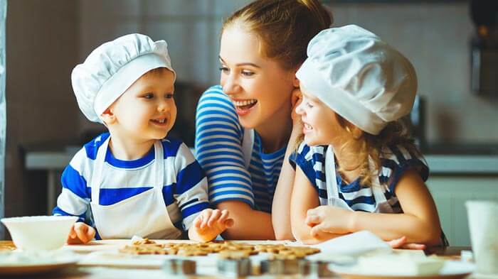 Happy mother and her kids cook cookies